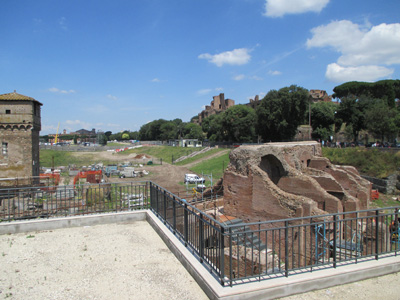 Photo shows the remains of a two-story structure to the right of the tower.  Arches along the bottom would allow people to enter the horsetrack, and on the second story is a covered hallway running along the horsetrack.